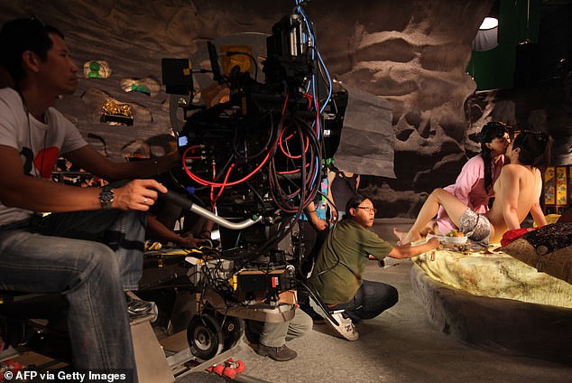 Victims of the horrific porn trap have recalled being approached in the street before being lured away to hidden offices and raped by up to 15 men in front of a camera. Pictured:&nbsp;Japanese actors perform for the camera during filming on the set of Sex and Zen: Extreme Ecstacy in Hong Kong on August 13, 2010