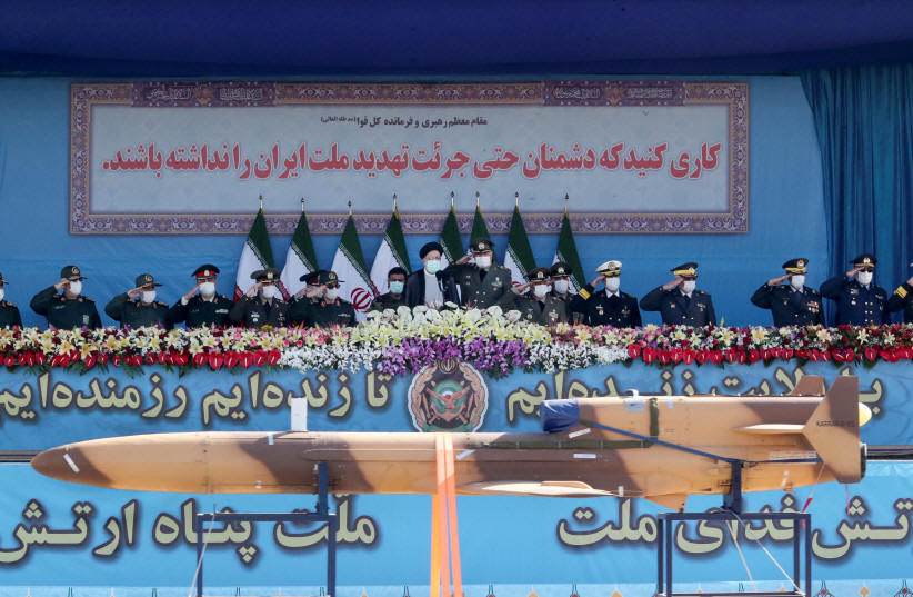  Iranian President Ebrahim Raisi and military commanders watch as military equipment passes by during a ceremony of the National Army Day parade in Tehran, Iran April 18, 2022.  (photo credit: REUTERS)